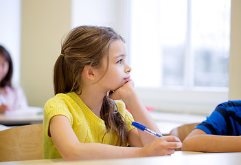 Image showing school girl with pen being bored in classroom