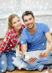 Image showing smiling couple with tablet pc at home