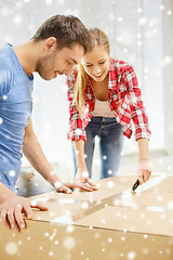 Image showing smiling couple opening big cardboard box