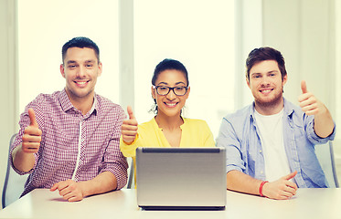 Image showing three smiling colleagues with laptop in office