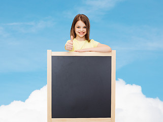 Image showing happy little girl with blank blackboard