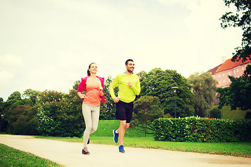 Image showing smiling couple running outdoors