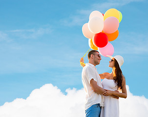 Image showing smiling couple with air balloons outdoors