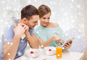 Image showing smiling couple with tablet pc having breakfast