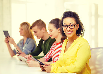 Image showing smiling female students with tablet pc at school