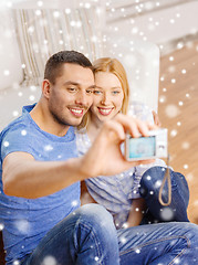 Image showing smiling couple taking picture with digital camera