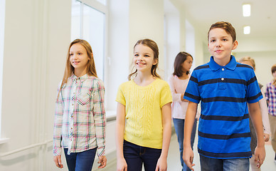 Image showing group of smiling school kids walking in corridor