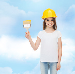 Image showing smiling little girl in helmet with paint brush