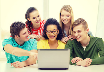 Image showing smiling students looking at laptop at school