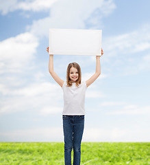 Image showing smiling little girl holding blank white board