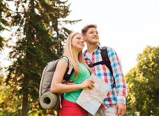 Image showing smiling couple with map and backpack in nature