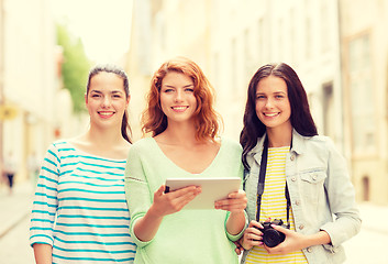 Image showing smiling teenage girls with tablet pc and camera