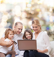 Image showing happy family with laptop computer and credit card