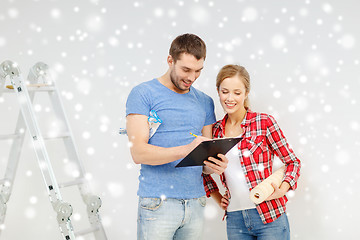 Image showing smiling couple with clipboard and wallpaper roll