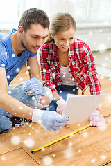 Image showing smiling couple measuring wood flooring