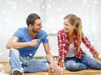 Image showing smiling couple measuring wood flooring