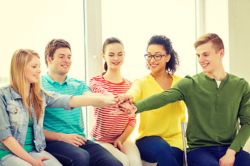 Image showing smiling students with hands on top of each other