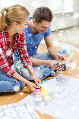 Image showing smiling couple selecting color from samples