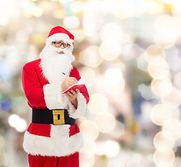 Image showing man in costume of santa claus with notepad