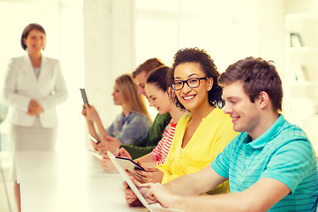 Image showing smiling female students with tablet pc at school