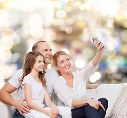 Image showing happy family with camera at home