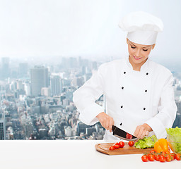 Image showing smiling female chef chopping vegetables