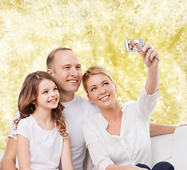 Image showing happy family with camera at home