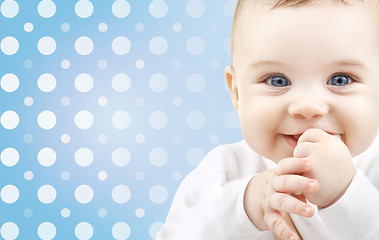 Image showing smiling baby boy face over blue polka dots