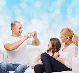 Image showing happy family with camera at home