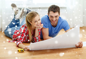 Image showing smiling couple with  blueprint at home