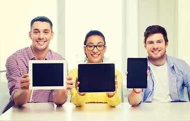 Image showing smiling colleagues showing tablet pc blank screen