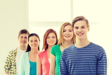 Image showing smiling students with teenage boy in front