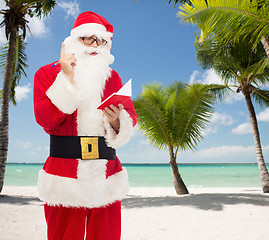 Image showing man in costume of santa claus with notepad