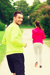 Image showing smiling couple running outdoors