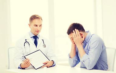 Image showing doctor with clipboard and patient in hospital