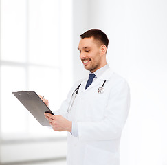 Image showing smiling male doctor with clipboard and stethoscope