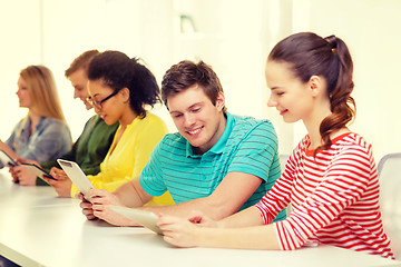 Image showing smiling students looking at tablet pc at school