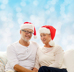 Image showing happy senior couple in santa helper hats