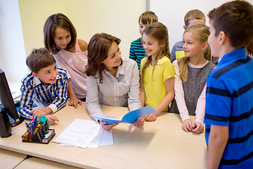 Image showing group of school kids with teacher in classroom