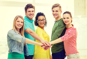 Image showing smiling students with hands on top of each other