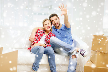 Image showing smiling couple relaxing and waving hand at home