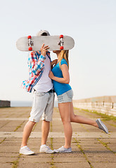 Image showing couple with skateboard kissing outdoors