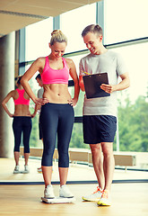 Image showing smiling man and woman with scales in gym