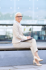 Image showing young smiling businesswoman with notepad outdoors