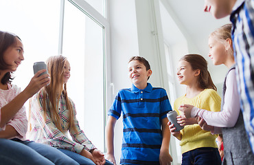 Image showing group of school kids with soda cans in corridor