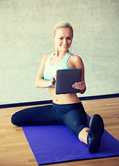 Image showing smiling woman with tablet pc in gym