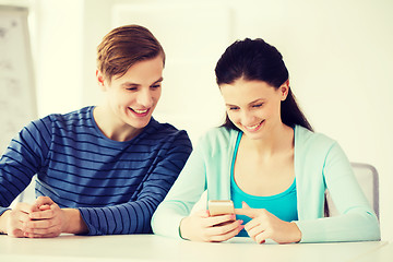 Image showing two smiling students with smartphone at school