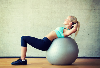 Image showing smiling woman with exercise ball in gym