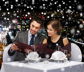 Image showing smiling couple with menus at restaurant