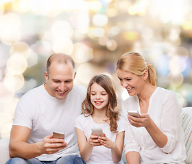 Image showing happy family with smartphones